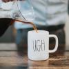 Software engineer pouring coffee into a mug that says "UGH"